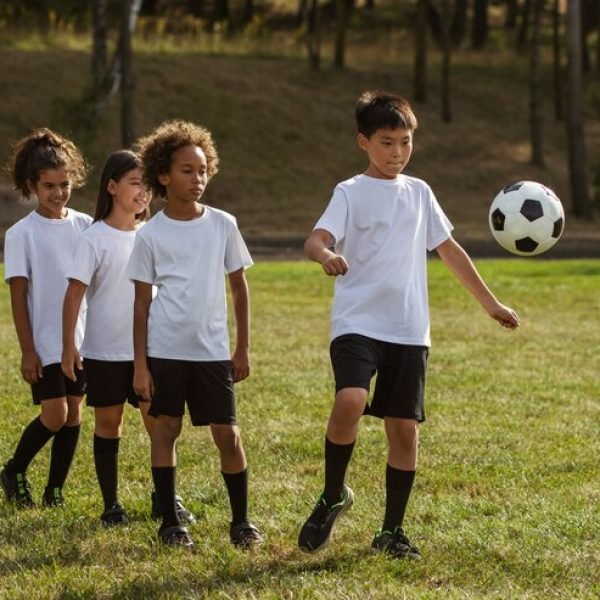 criancas-jogando-futebol-supervisionadas-por-treinador-de-futebol_23-2149684384