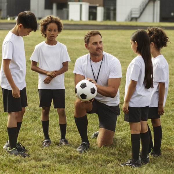 kids-playing-football-supervised-by-football-trainer